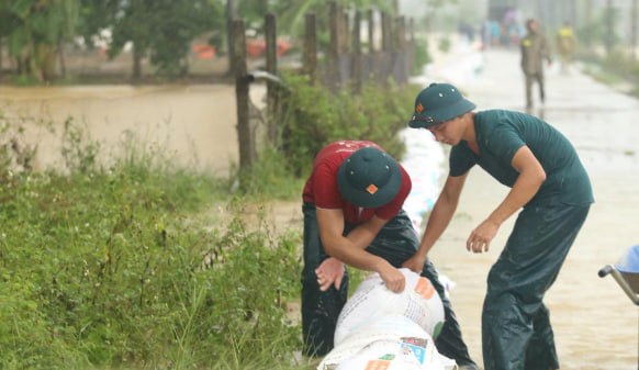越南河内裴河洪水超三级警报，数百人冒雨筑堤抗洪